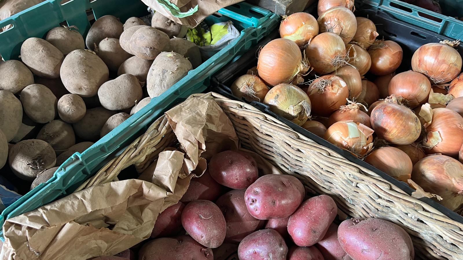 Potatoes and onions on display in the farm shop