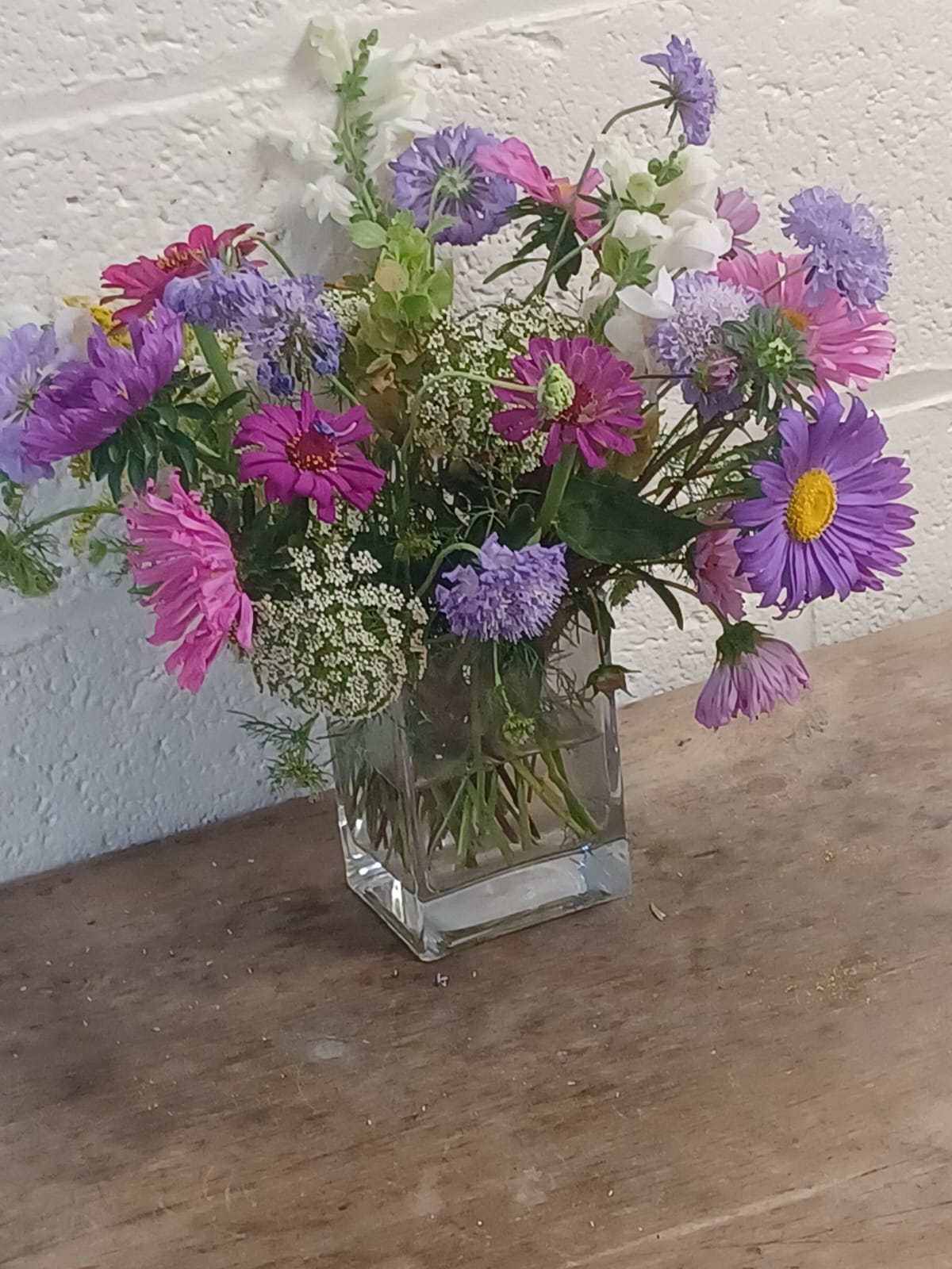 A vase of colourful wildflowers on a farm table